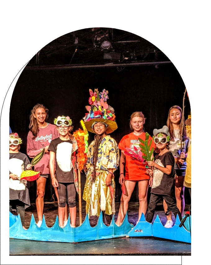 Photo of children in group performance on a stage in colorful costumes