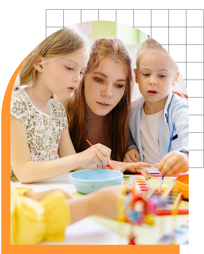 Young woman helping two small children with their arts and crafts