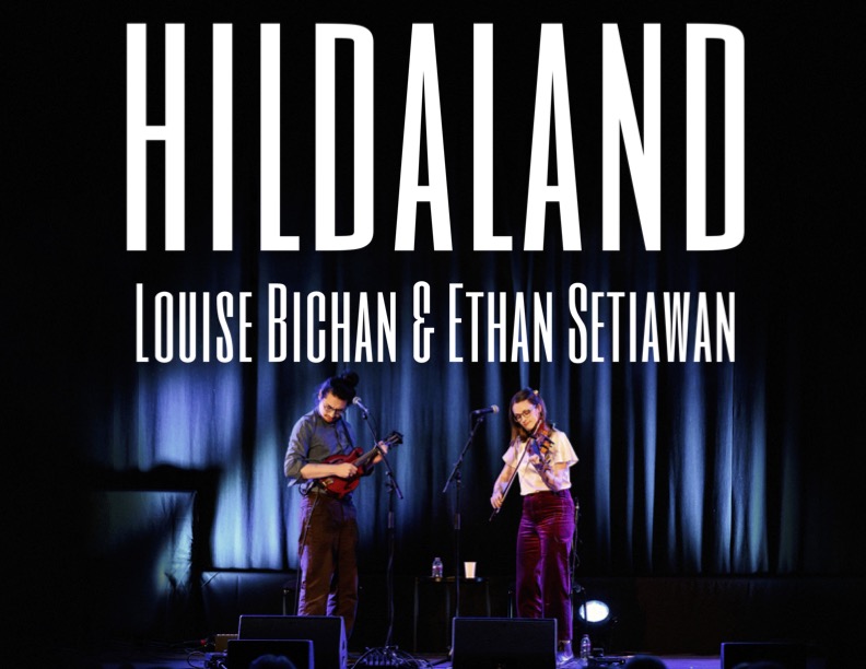 Two musicians, one playing a mandolin and the other a fiddle, perform on a dimly lit stage with blue curtains. Large text above reads “HILDALAND Louise Bichan & Ethan Setiawan.”.