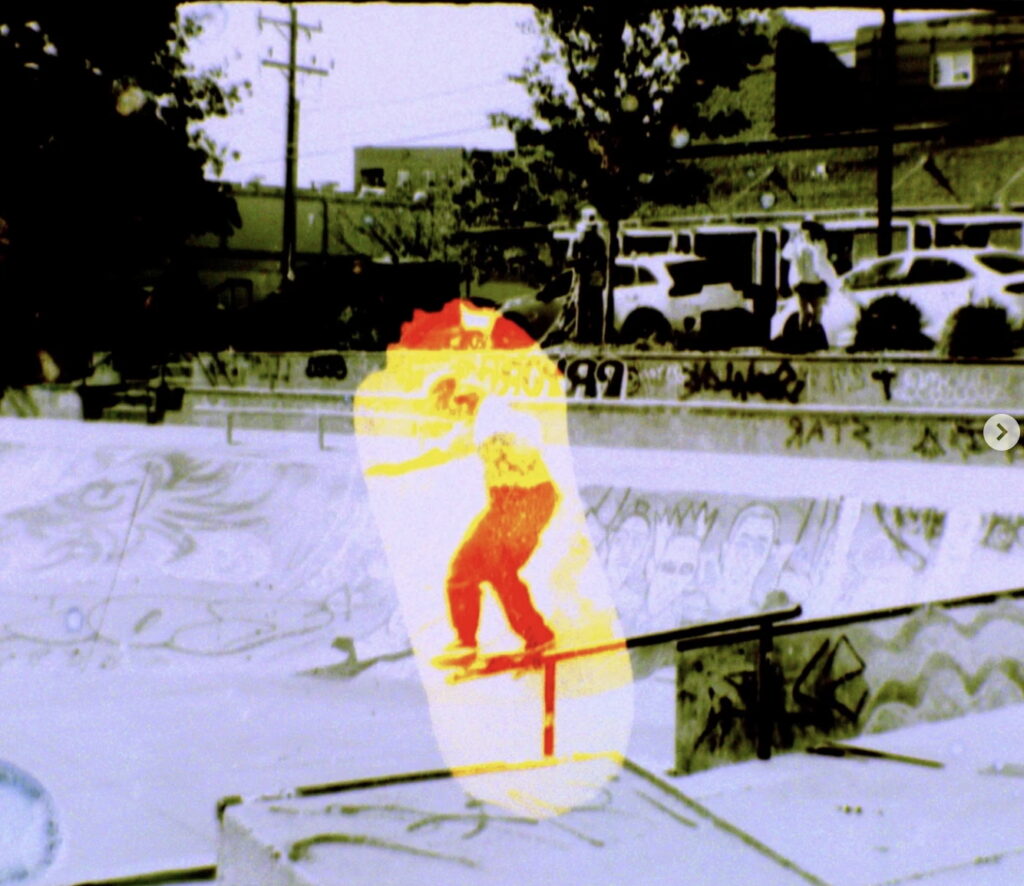 A skateboarder slides on a rail in a graffiti-covered skatepark, highlighted by a bright yellow and red overlay.